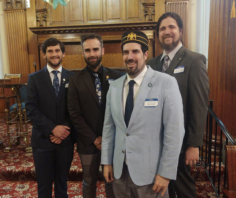 Four 32° Scottish Rite Masons standing on the stairs together in the Valley of Utica lodge room during Reunion season