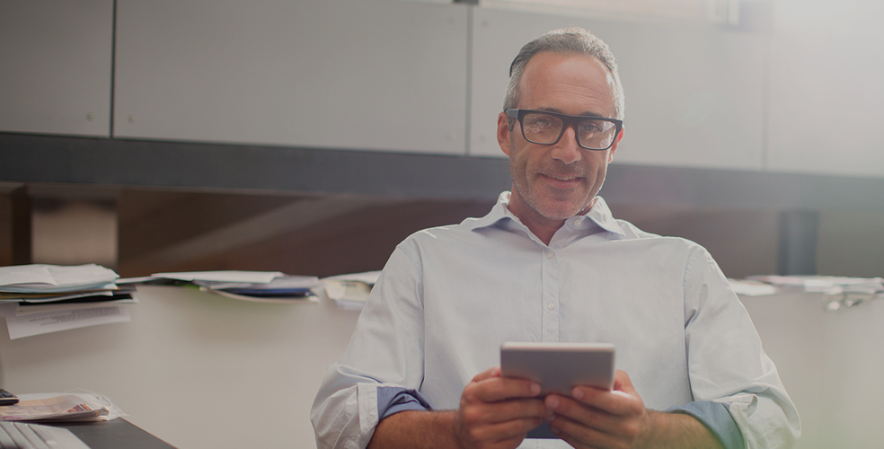 man in office with tablet in hand