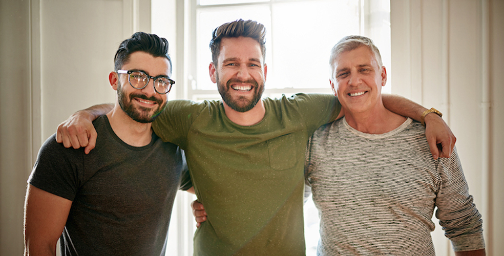 three men arm in arm smiling