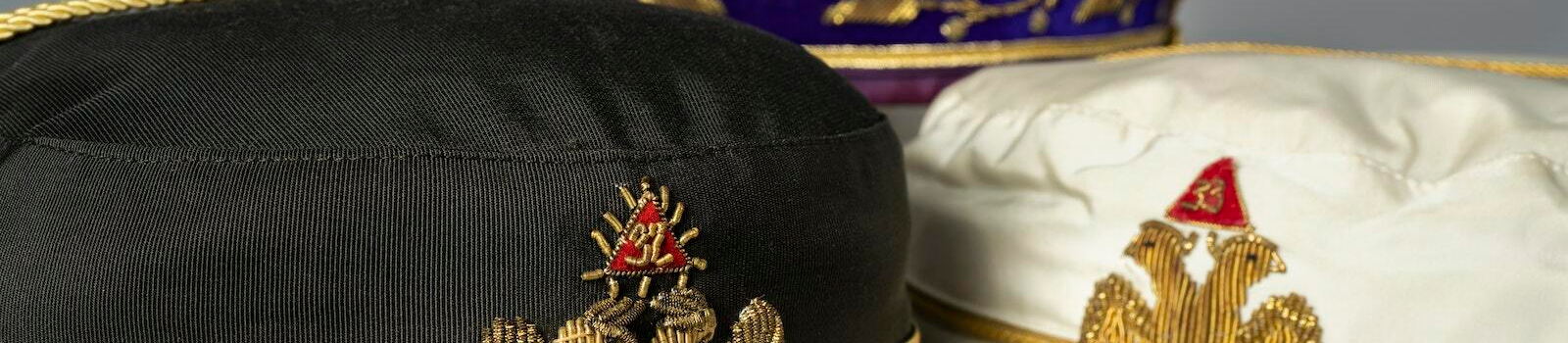 Scottish Rite, NMJ Caps ranging in hierarchy, A black cap for 32° Scottish Rite Freemasons, a White Cap for 33° Supreme Council Active Members, and a 33° Purple Cap the Sovereign Grand Commander wears.