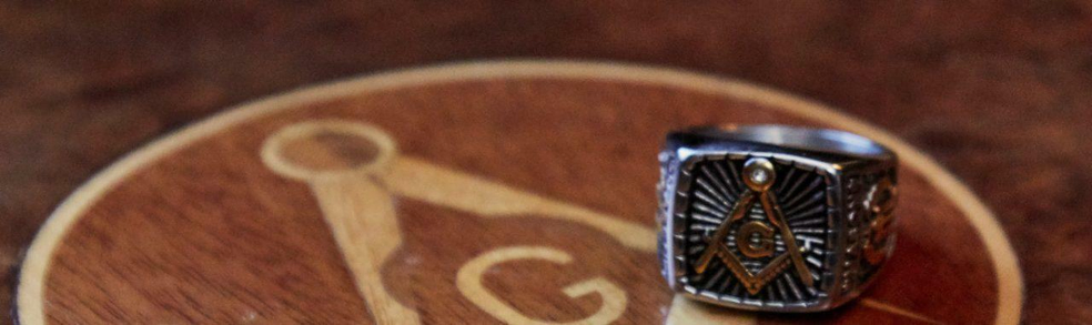 masonic square and compasses emblem on table and masonic ring