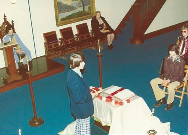 A young man standing at the altar of a Masonic Lodge