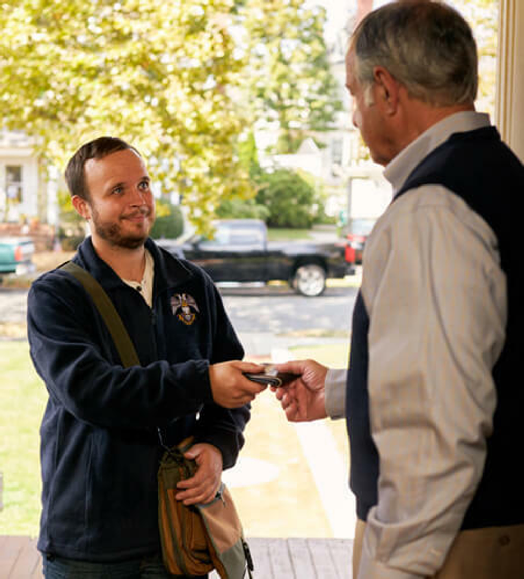 Scottish Rite mason handing another man back his wallet that he lost