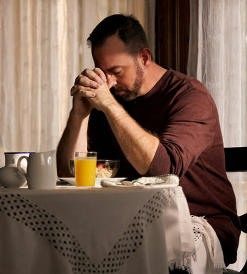 man praying at the table