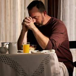 man praying at the table