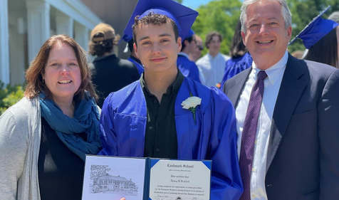 a graduate with his parents showing off his diploma