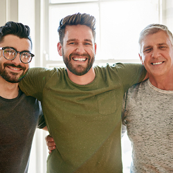 three men arm in arm smiling