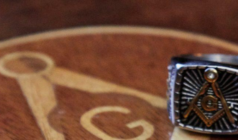 masonic square and compasses emblem on table and masonic ring