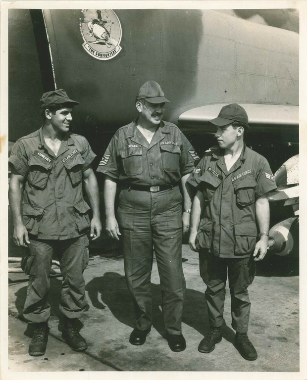 Three Air Force members standing in front of a plane