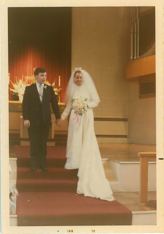 A man and woman on their wedding day, standing at the altar