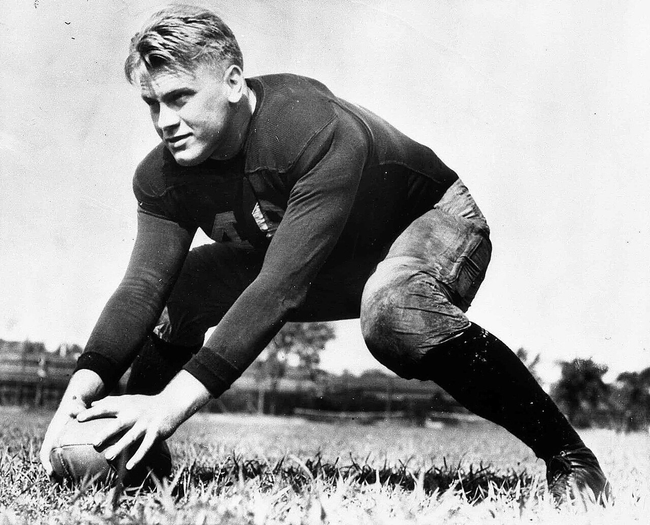 Gerald Ford playing football in uniform at the University of Michigan