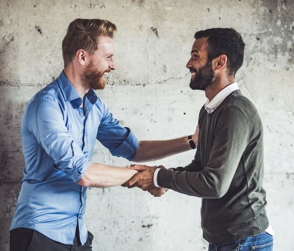 two middle aged men shaking hands