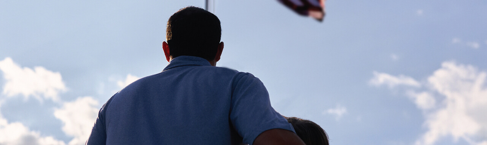 father and son looking at flag