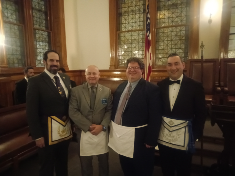 A group of Masons at lodge wearing Masonic aprons