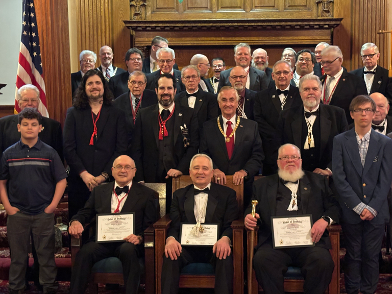 A group of Masons pose behind three award recipients