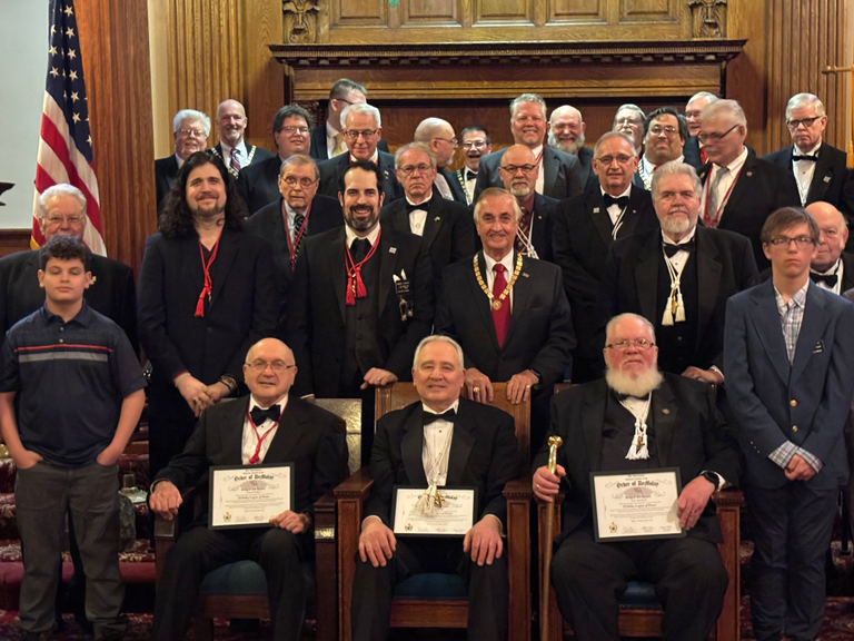 A group of Masons pose behind three award recipients