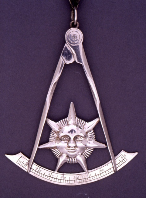 Past Master’s Jewel in the shape of the sun inside a square and compasses.