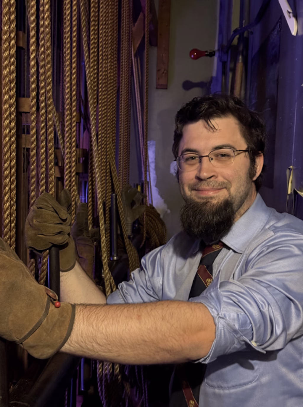 John Knowton, a Scottish Rite Mason, wearing gloves and pulling curtain ropes behind the scenes of a degree production
