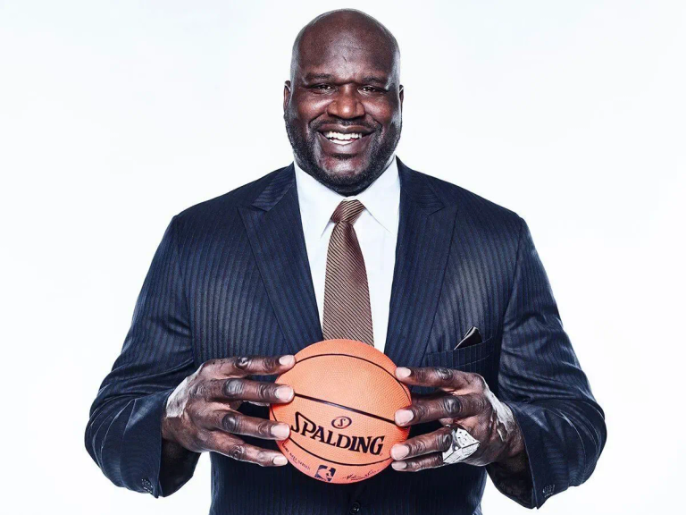 Shaquille O'Neal smiling and holding a basketball