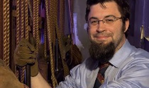 Fran Hart, a Scottish Rite Freemason, dressed in colonial attire, standing in front of a green screen for a production of the 20th degree, Master Ad Vitam