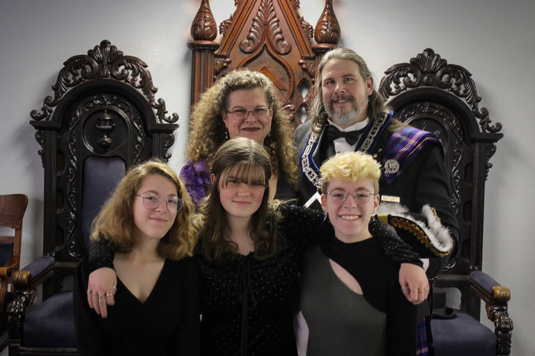 A Mason pictured alongside his wife and two kids in a Masonic lodge room