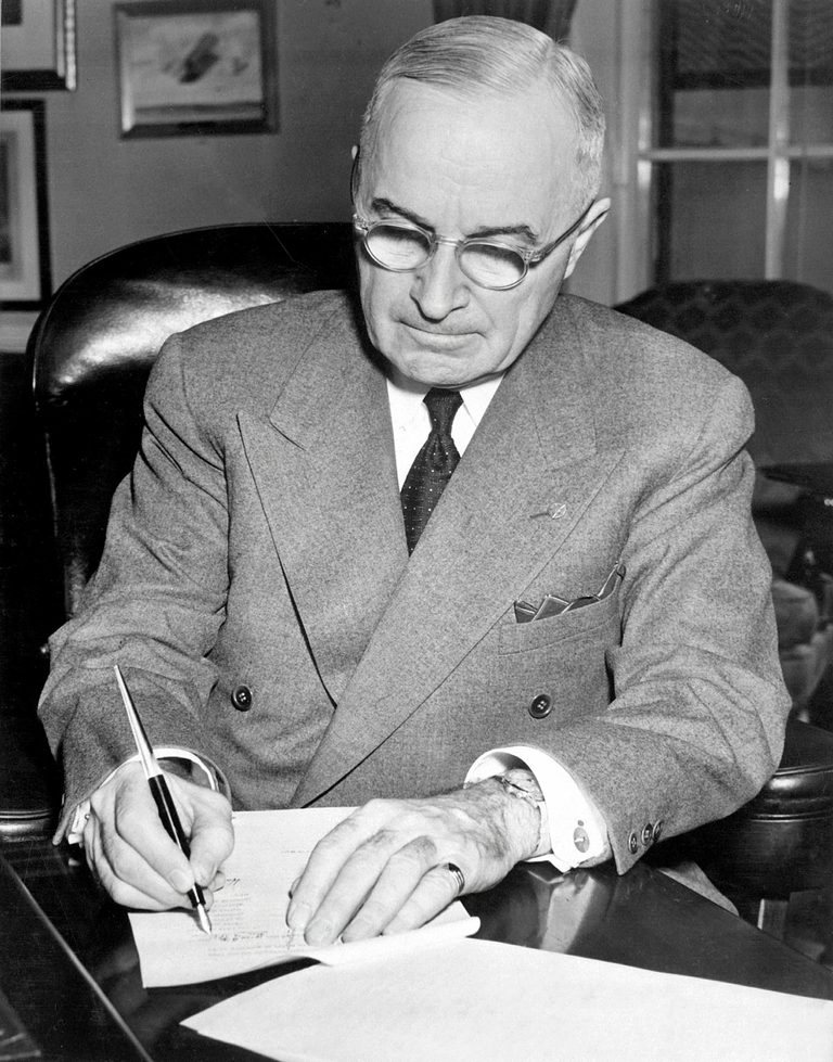 President Harry S. Truman working at his desk in the White House
