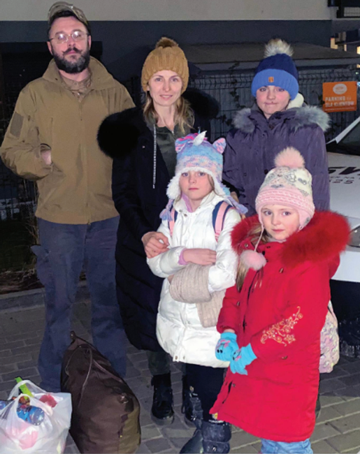A Freemason standing alongside a Ukranian refugee family he helped bring to safety