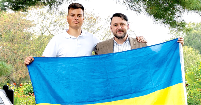 Freemason Chase Wilhelm holding a Ukranian flag alongside a refugee
