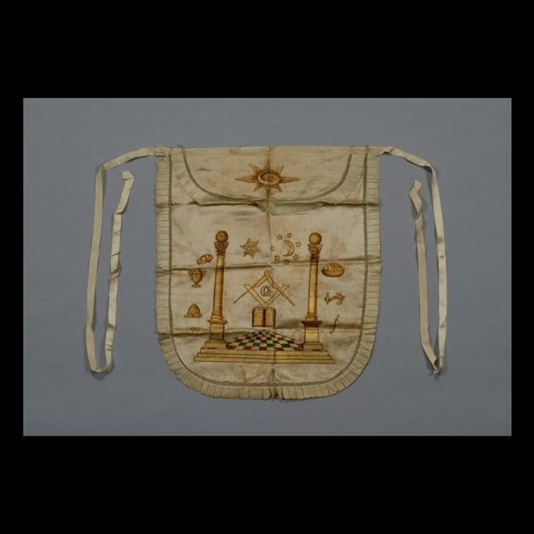 A Masonic apron with symbols such as the square and compasses, columns, the sun, and more.
