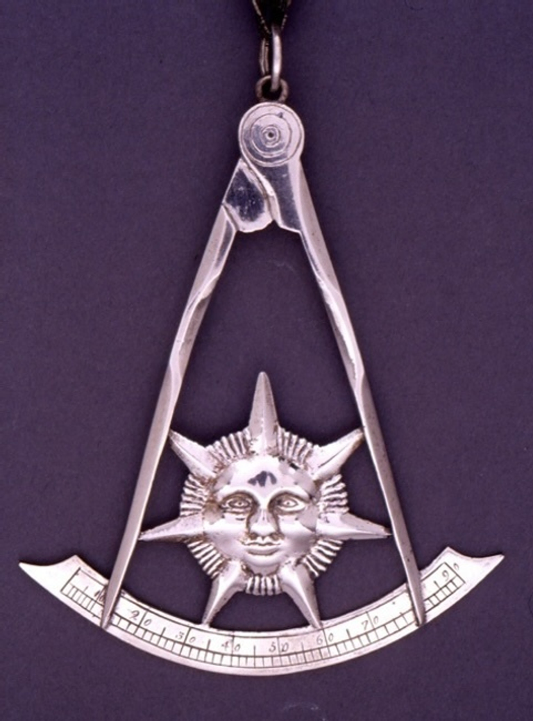Past Master’s Jewel in the shape of the sun inside a square and compasses.