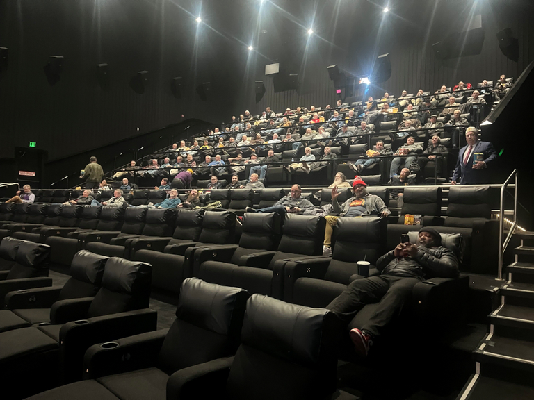 A movie theater filled with over 100 guests