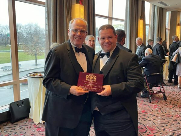 Two Freemasons holding an award