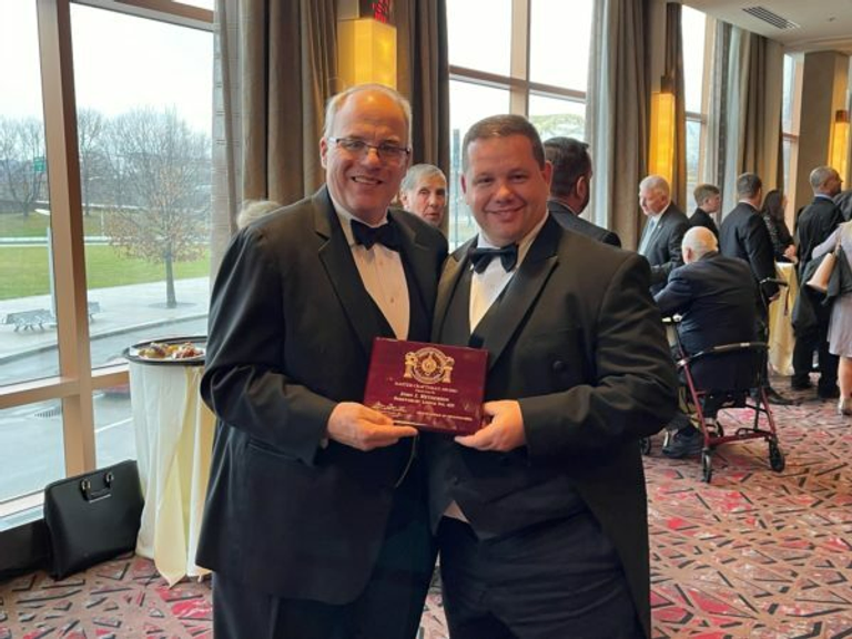 Two Freemasons holding an award