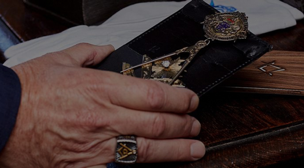 A hand with a ring on a Masonic Jewel